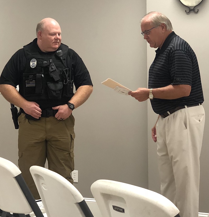 Officer Mark Haley, left, is recognized at the board's meeting by Mayor Virgil Holder.