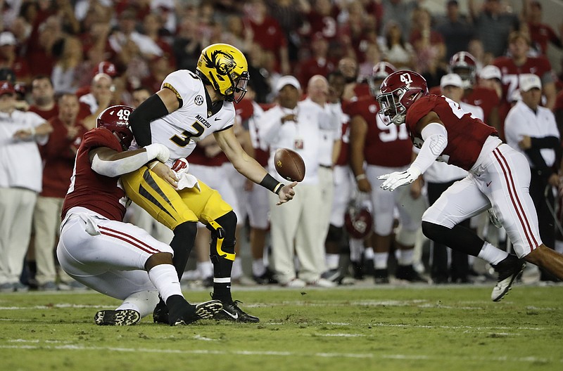Alabama defensive end Isaiah Buggs (49) strips Missouri quarterback Drew Lock of the ball Saturday night as outside linebacker Christian Miller (47) looks on. The Crimson Tide won 39-10 and are 7-0 entering this weekend's trip to Tennessee, which is coming off an upset of Auburn.