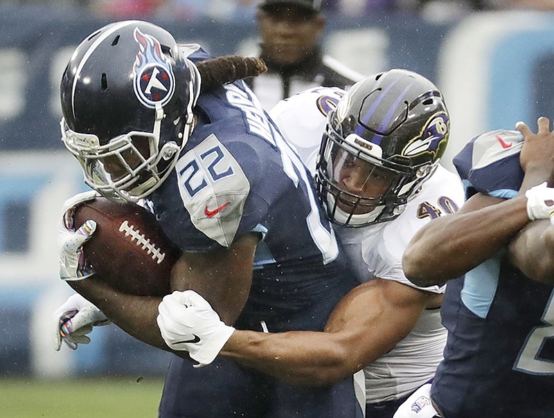 Tennessee Titans running back Derrick Henry is tackled by Baltimore Ravens linebacker Kenny Young during the first half of Sunday's game in Nashville.