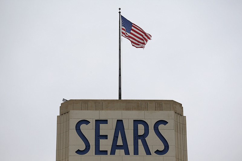 An American flag flies above a Sears department store sign in Hackensack, N.J., Monday, Oct. 15, 2018. Sears filed for Chapter 11 bankruptcy protection Monday, buckling under its massive debt load and staggering losses. (AP Photo/Seth Wenig)