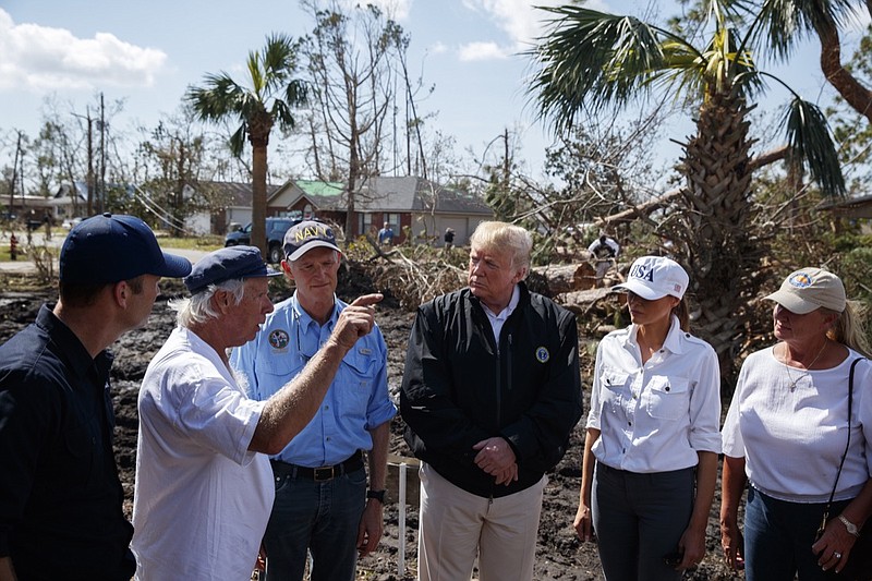 A Lynn Haven, Fla., homeowner, second left, talks with from left, FEMA director Brock Long, Florida Gov. Rick Scott, third from left, President Donald Trump, first lady Melania Trump and Margo Anderson, Mayor of Lynn Haven, Fla., as they tour a neighborhood affected by Hurricane Michael, Monday, Oct. 15, 2018, in Lynn Haven, Fla. (AP Photo/Evan Vucci)