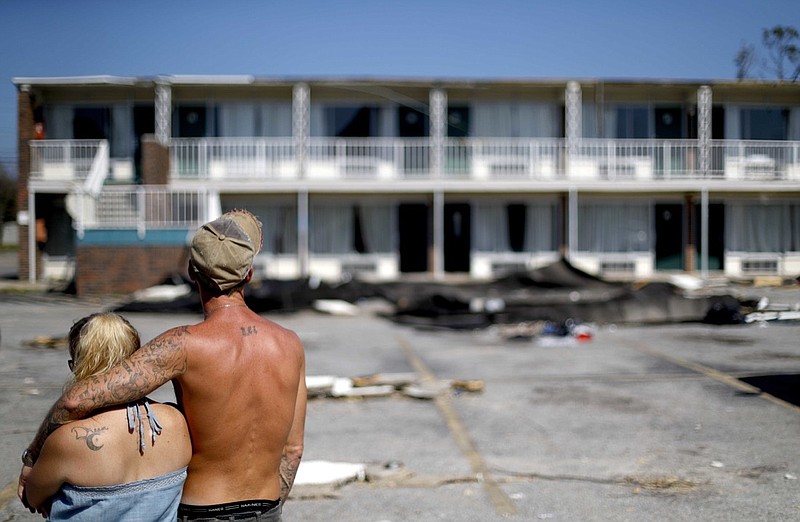 Residents line up for food from the Red Cross outside a damaged motel, Tuesday, Oct. 16, 2018, in Panama City, Fla., where many residents continue to live in the aftermath of Hurricane Michael. Some residents rode out the storm and have no place to go even though many of the rooms at the motel are uninhabitable. (AP Photo/David Goldman)