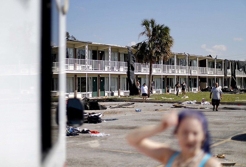 Residents come out out to a Red Cross food truck visiting the damaged motel where many continue to live despite the destruction in the aftermath of Hurricane Michael in Panama City, Fla., Tuesday, Oct. 16, 2018. (AP Photo/David Goldman)

