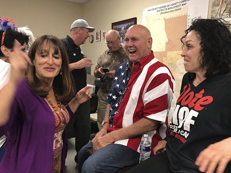 In this June 12, 2018, file photo, Nevada brothel owner Dennis Hof, second from right, celebrates with Heidi Fleiss, right, and others after winning the primary election in Pahrump, Nev. Hof, a legal pimp who has fashioned himself as a Donald Trump-style Republican candidate has died, Nevada authorities said Tuesday, Oct. 16, 2018. (David Montero//Los Angeles Times via AP, File)