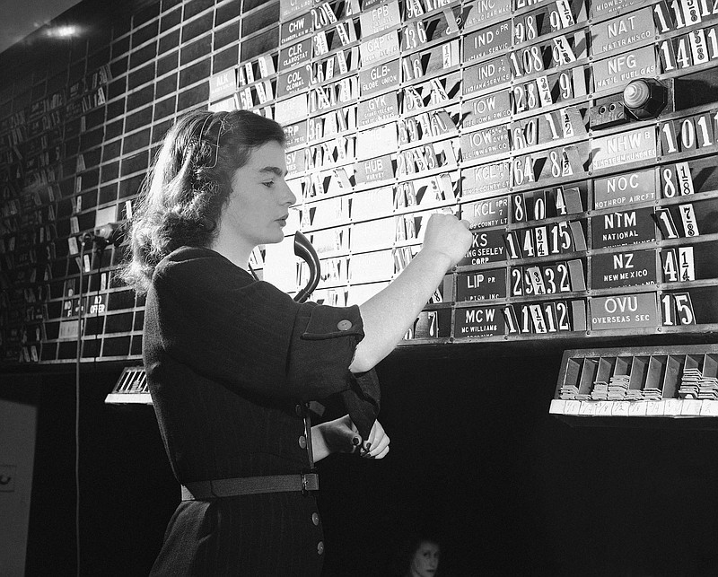 FILE- In this Sept. 6, 1947, file photo Dolores Hennessy, bulletin clerk in the quotation department, changes bid and asked prices on the information relayed to her from the central tube room in New York. The lettered cards carry symbols for Curb Exchange stock issues while the numbered cards show the current market in those issues. The S&P 500, the stock market’s benchmark index, has climbed in the 12 months after each of the midterm elections going back to 1946. That’s 18 elections, many of which ended up shuffling the balance of power in Congress. (AP Photo/Dan Grossi, File)