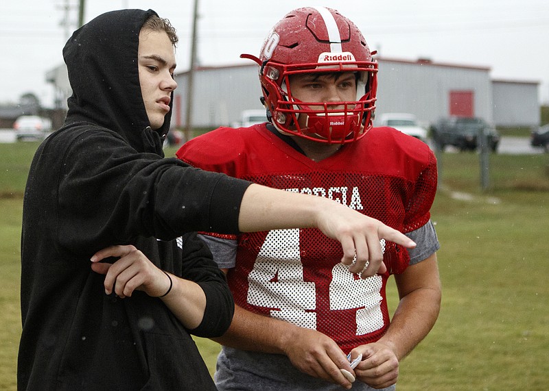 Daniel O'Steen, left, talks with James Beddington during football practice Tuesday at Lakeview-Fort Oglethorpe High School. O'Steen, who gave up football after two major knee surgeries, has taken on a student coaching role.