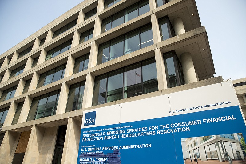 FILE- In this Aug. 27, 2018, file photo a sign stands at the construction site for the Consumer Financial Protection Bureau's new headquarters in Washington. The nation’s financial watchdog has opened a formal investigation into writings and comments by Eric Blankenstein, a Republican appointee overseeing the agency’s anti-discrimination efforts, which he alleged that most hate crimes were fake and argued that using racial epithets did not mean a person was racist. (AP Photo/Andrew Harnik, File)