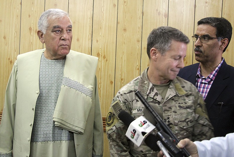 Kandahar Gov. Zalmay Wesa, left, stands with the head of NATO troops in Afghanistan, Gen. Scott Miller, center, and a translator, during a meeting, in Kandahar, Afghanistan, Thursday, Oct. 18, 2018. The three top officials in Afghanistan's Kandahar province were killed, including Wesa, when their own guards opened fire on them at the security conference Thursday, the deputy provincial governor said. A Taliban spokesman said the target was Miller, who escaped without injury, according to NATO. (AP Photo)