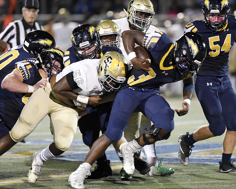 Christian's Mondo Ellison (3) bulls a head for yardage as Notre Dame's Ramcey Watson (56) holds onto his jersey.  The Chattanooga Christian School Chargers hosted the Notre Dame Fighting Irish in a TSSAA rivalry game on October 19, 2018