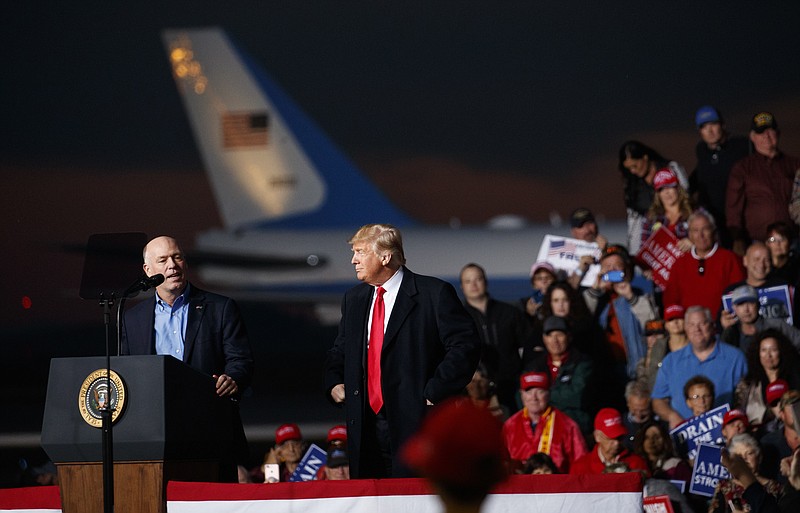 Rep. Greg Gianforte, R-Mont., speaks as President Donald Trump stands right during a campaign rally at Minuteman Aviation Hangar, Thursday, Oct. 18, 2018, in Missoula, Mont. (AP Photo/Carolyn Kaster)