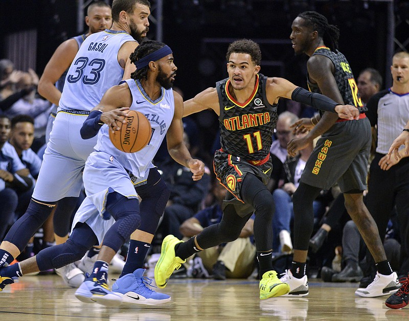 Memphis Grizzlies guard Mike Conley, left, drives toward the basket against Atlanta Hawks guard Trae Young during the first half of Friday night's game in Memphis.