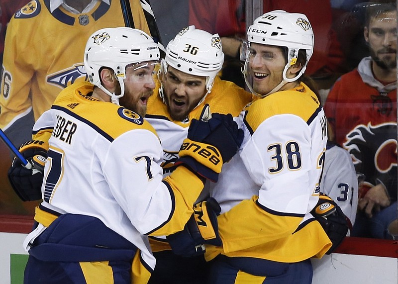 The Nashville Predators' Zac Rinaldo, center, celebrates his goal with teammates Yannick Weber, left, and Ryan Hartman during Friday night's 5-3 road win against the Calgary Flames.
