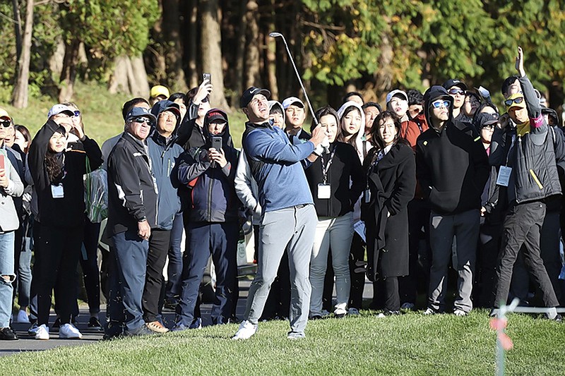 Brooks Koepka and members of the gallery track his shot on the 10th hole during Thursday's opening round of the CJ Cup at Nine Bridges on South Korea's Jeju Island. Koepka had a four-stroke lead after his third-round 67 on Saturday and is looking for a win as he tries to take over the top spot in the World Golf Ranking.