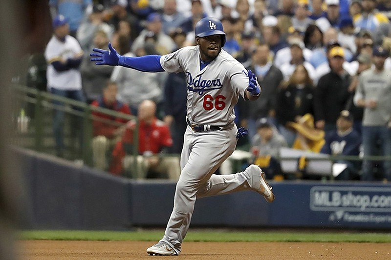 The Los Angeles Dodgers' Yasiel Puig celebrates as he rounds the bases at Miller Park after hitting a three-run homer during Game 7 of the National League Championship Series on Saturday night in Milwaukee. The Dodgers beat the Brewers 5-1 to advance to the World Series against the Boston Red Sox. The Fall Classic starts Tuesday night at Boston's Fenway Park.