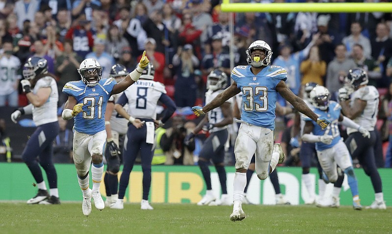 Los Angeles Chargers defensive backs Adrian Phillips (31) and Derwin James (33) celebrate after denying the Tennessee Titans on a 2-point conversion attempt during the final minute of Sunday's game at Wembley Stadium in London. The Chargers won 20-19.