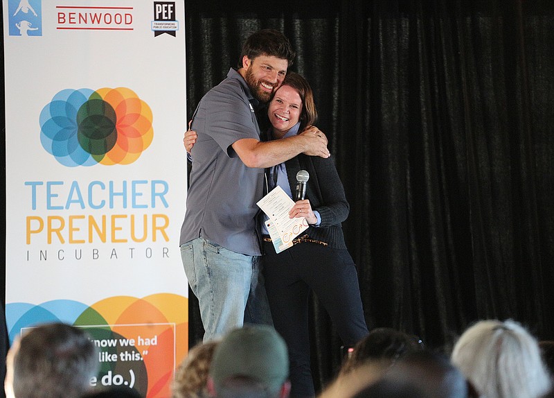 Michael Caraccio, a teacher from Sale Creek Middle/High School, hugs Maeghan Jones, the president of the Community Foundation of Greater Chattanooga, after she announces that Caraccio won the largest money prize during the Public Education Foundation Teaherpreneur Incubator Pitch Night Sunday, October 21, 2018 at the Chattanooga Whiskey Event Hall in Chattanooga, Tennessee. Caraccio's project, Tiny Curriculum...Big Impact, won both the first place prize chosen by judges as well as the crowd favorite prize.