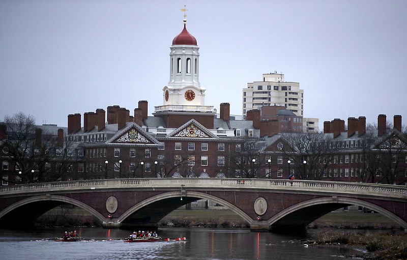 In this March 7, 2017 file photo, rowers paddle down the Charles River past the campus of Harvard University in Cambridge, Mass. A lawsuit alleging racial discrimination against Asian American applicants in Harvard's admissions process is heading to trial in Boston's federal court this week. (AP Photo/Charles Krupa, File)