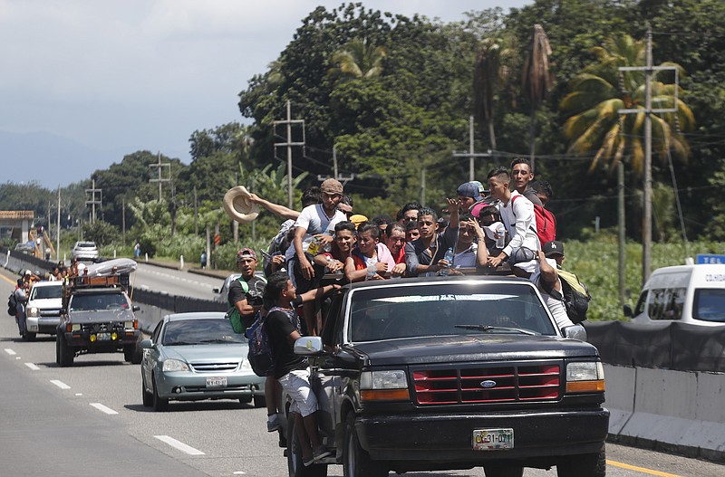 Central American migrants making their way to the U.S. in a large caravan fill the truck of a driver who offered them a free ride as they arrive in Tapachula, Mexico, on Sunday. (AP Photo/Moises Castillo)