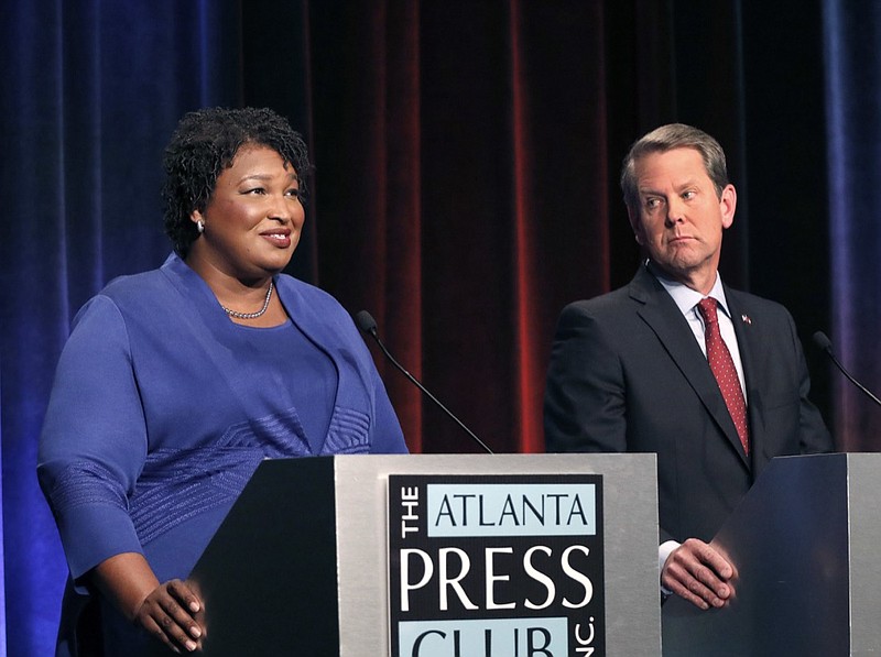 In this Tuesday, Oct. 23, 2018, file photo, Democratic gubernatorial candidate for Georgia Stacey Abrams, left, speaks as her Republican opponent Secretary of State Brian Kemp looks on during a debate in Atlanta. A federal judge says Georgia election officials must stop rejecting absentee ballots and absentee ballot applications because of a mismatched signature without first giving voters a chance to fix the problem. U.S. District Judge Leigh May on Wednesday, Oct. 24, 2018 ordered the secretary of state's office to instruct county election officials to stop the practice for the November midterm elections. She outlined a procedure to allow voters to resolve alleged signature discrepancies.(AP Photo/John Bazemore, Pool, File)