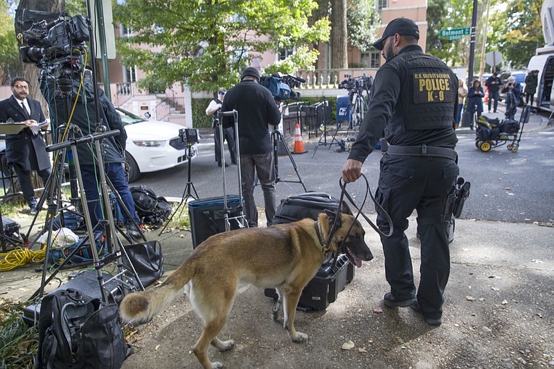 An officer with the Uniform Division of the United States Secret Service uses his dog to search a checkpoint near the home of President Barack Obama, Wednesday, Oct. 24, 2018, in Washington. The U.S. Secret Service says agents have intercepted packages containing "possible explosive devices" addressed to former President Barack Obama and Hillary Clinton. (AP Photo/Alex Brandon)

