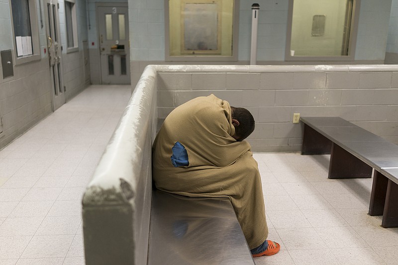 Staff Photo by Dan Henry / The Chattanooga Times Free Press- 4/5/17. An inmate covers up to keep warm while waiting to be locked up at the Hamilton County Jail in downtown Chattanooga on April 5, 2017. 