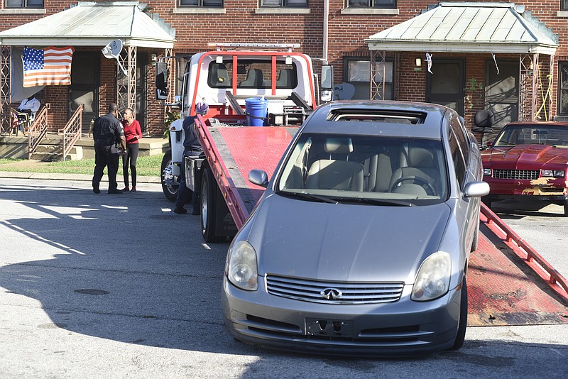 Chattanooga police impound a stolen car from a parking lot at the East Lake Courts on Tuesday, Oct. 13, 2015, in Chattanooga, Tenn. 