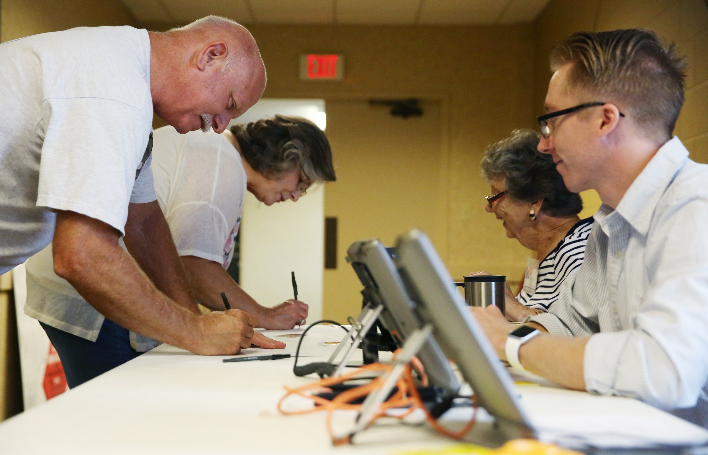 Gary Williams and Karen Williams of Chickamauga are helped by assistant managers Mildred Long and Chad Henderson at the voting precinct at the Chattanooga Valley Church of the Nazarene Tuesday, July 24, 2018 in Flintstone, Georgia. Each voter is required to fill out paperwork, show photo identification and be checked in a voting database before they are allowed to vote.