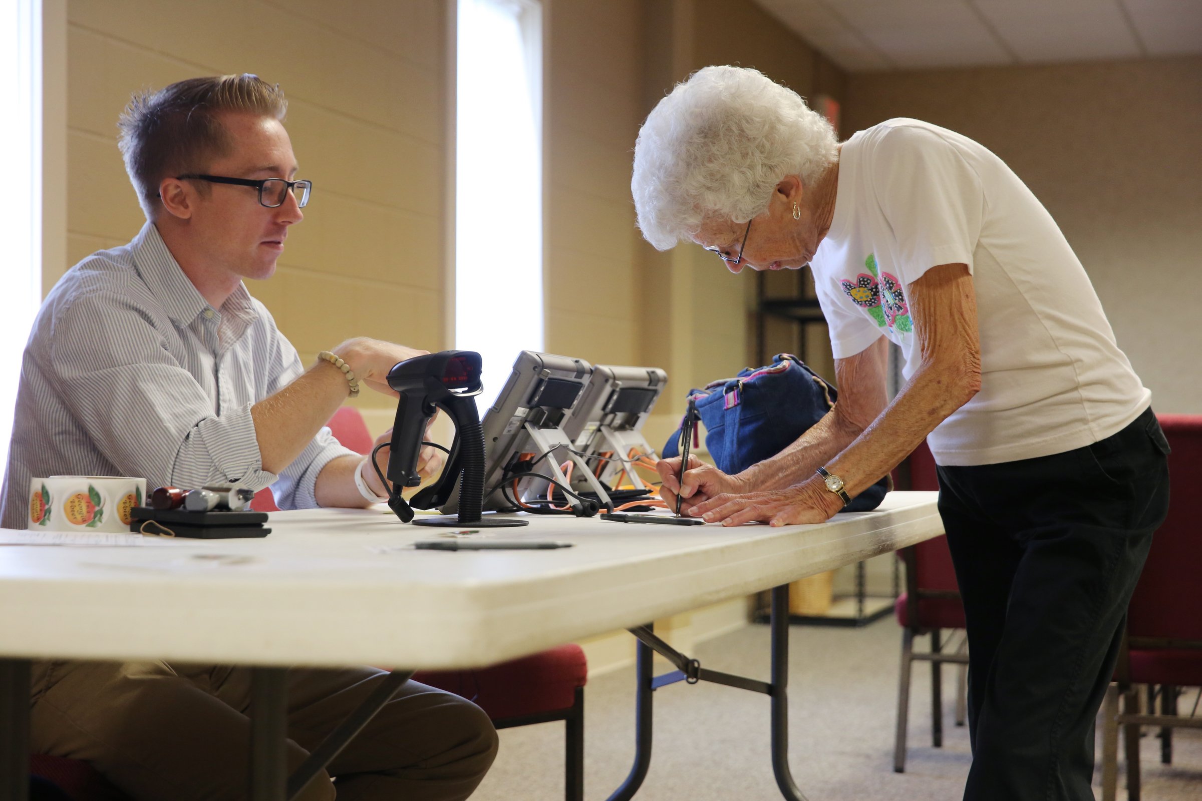 Joan Winkler of Flintstone fills out paperwork before voting in Georgia's runoff election Tuesday, July 24, 2018 at the Chattanooga Valley Church of the Nazarene in Flintstone, Georgia. Each voter is required to fill out paperwork, show photo identification and be checked in a voting database before they are allowed to vote.