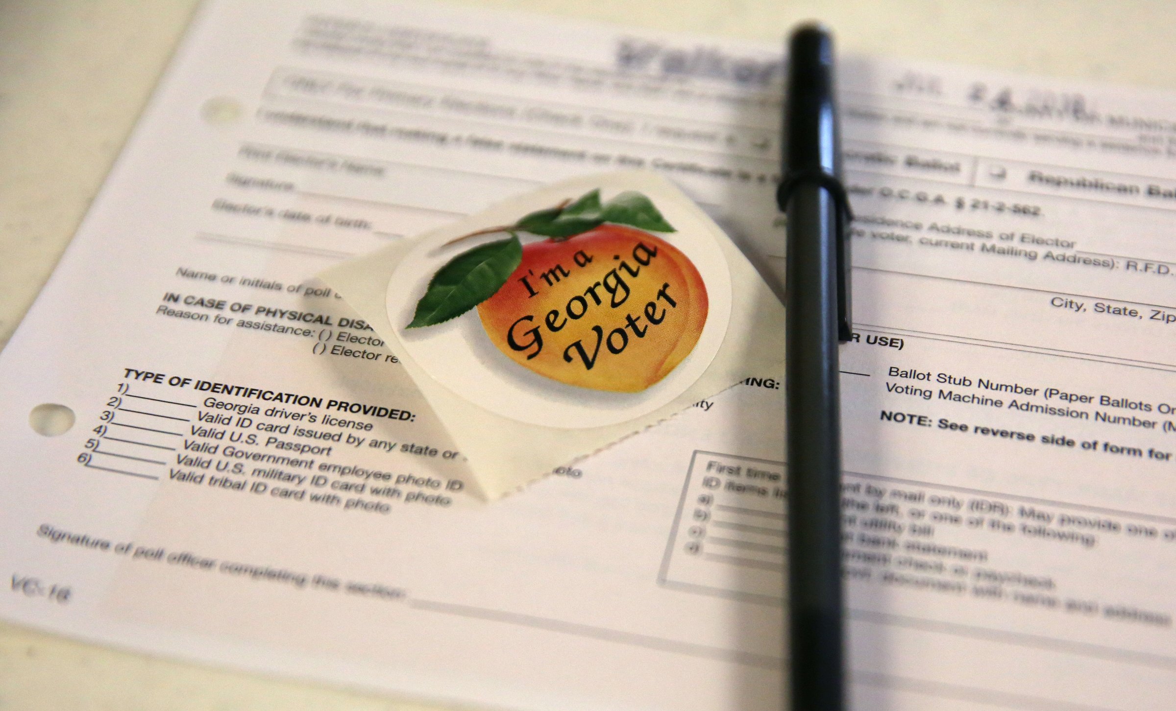 Paperwork and voting stickers sit out for voters of the Georgia primary election Tuesday, July 24, 2018 at the Chattanooga Valley Church of the Nazarene in Flintstone, Georgia.