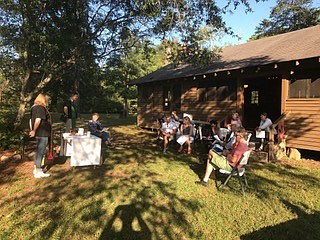 Attendees at St. Timothy's first pop-up church, held at McCoy Farm & Gardens, gather to pray before sharing a meal.