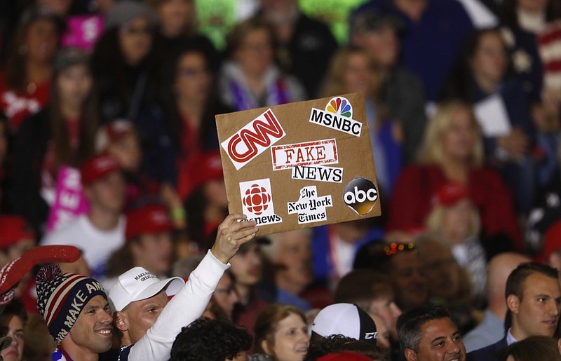 FILE - In this April 28, 2018 file photo, an audience member holds a 'fake news' sign during a President Donald Trump rally in Washington Township, Mich. Local members of the media says they've noticed more hostility from the public since Trump began his attacks on 'fake news.' Trade groups are spreading safety tips because of the incidents. (AP Photo/Paul Sancya, File)

