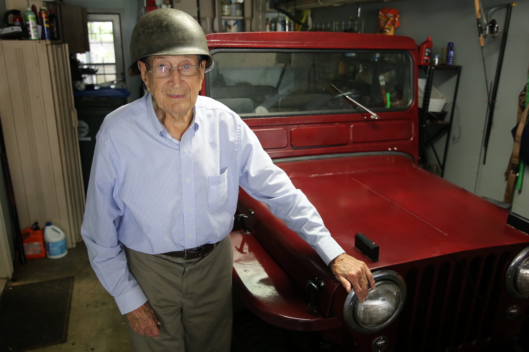 Ralph Painter poses for a photo with a Jeep he has rebuilt Monday, October 15, 2018 at his home in East Brainerd, Tennessee. The helmet Painter is wearing is from his time in World War II.