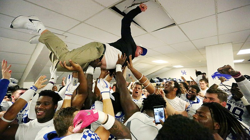Kentucky football coach Mark Stoops body surfs on top of his jubilant Wildcats after last Saturday's 15-14 win at Missouri.