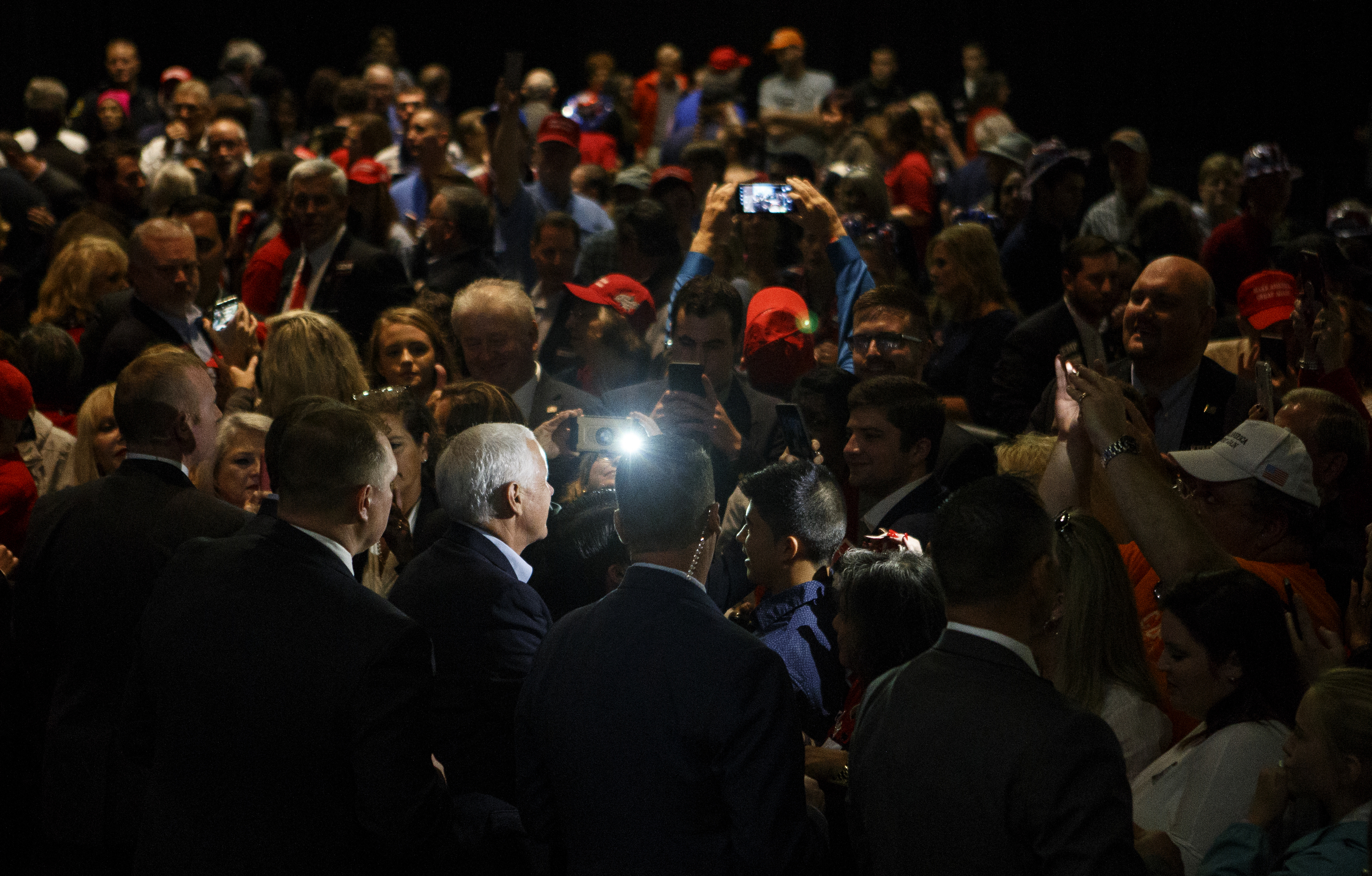 The flash from a camera phone illuminates Vice President Mike Pence as he greets supporters after speaking during a "Get Out The Vote" rally stumping for Republican gubernatorial candidate Brian Kemp at the Dalton Convention Center on Thursday, Nov. 1, 2018 in Dalton, Ga. Republican Brian Kemp is facing off against Democrat Stacey Abrams for governor in Georgia.