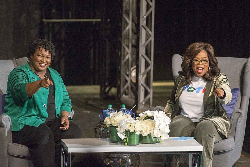 Oprah Winfrey and Georgia gubernatorial candidate Stacey Abrams greet a crowd gathered for a town hall conversation at the Cobb Civic Center's Jennie T. Anderson Theatre in Marietta, Ga., Thursday, Nov. 1, 2018. Winfrey visited Georgia on Thursday to canvass neighborhoods in Metro Atlanta and show her support for gubernatorial candidate Stacey Abrams. (Alyssa Pointer /Atlanta Journal-Constitution via AP)

