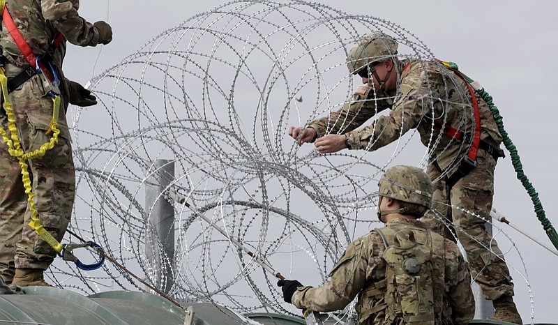 Members of the U.S.military place razor wire along the U.S.-Mexico border on the McAllen-Hidalgo International Bridge, Friday, Nov. 2, 2018, in McAllen, Texas. (AP Photo/Eric Gay)

