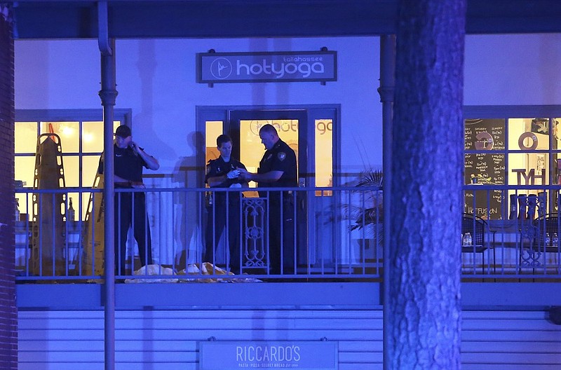 Police investigators work the scene of a shooting, Friday, Nov. 2, 2018, in Tallahassee, Fla. A shooter killed one person and critically wounded four others at a yoga studio in Florida's capital before killing himself Friday, officials said. (AP Photo/Steve Cannon)

