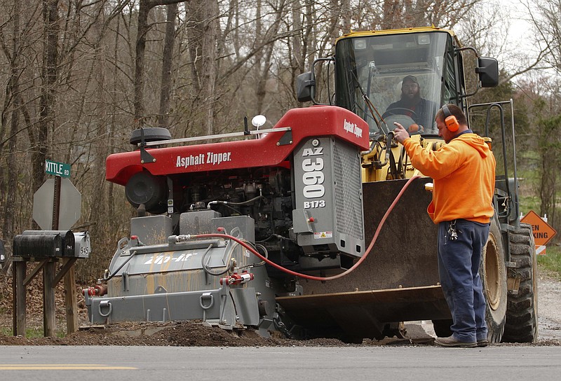 Staff Photo by Dan Henry - 4/3/13.  Michael Giles, left, and Jacob Crawford prepare the unimproved Kittle Road for paving early Wednesday afternoon. Kittle Road is one of four roads in Catoosa County that are being renovated this spring thanks to a $494,000 state grant and $281,000 generated by county sales tax. 	