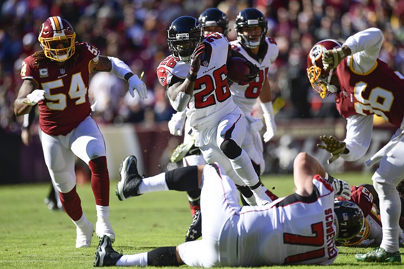Atlanta Falcons running back Tevin Coleman, center, breaks free from the pack for a 39-yard touchdown catch during the first half of Sunday's 38-14 win against the Washington Redskins in Landover, Md.
