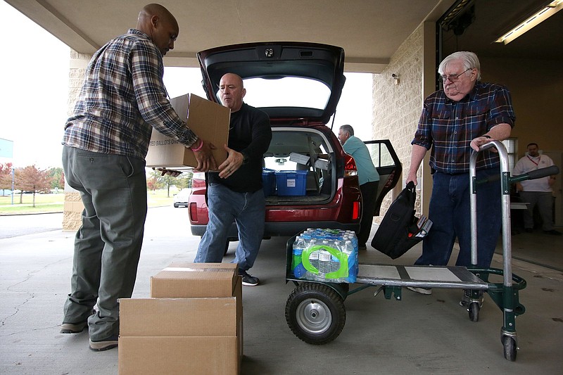 Ty Jacobs, a voting machine technician, Steve Gaston, an ICP support specialist, and Rodney Strong, a part-time worker, load voting supplies into the back of an election official's vehicle at the Hamilton County Election Commission Monday, November 5, 2018 in Chattanooga, Tennessee. Boxes with ballots, pens, voting official information, voting machines, privacy dividers, water and other supplies were loaded into the back of cars Monday to be taken to voting locations throughout Hamilton County.