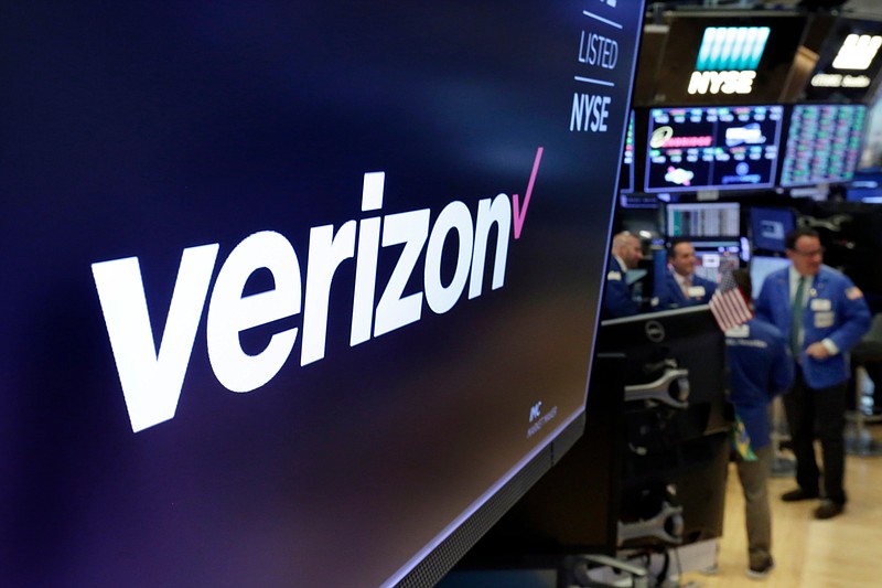 FILE- This April 23, 2018, file photo shows the logo for Verizon above a trading post on the floor of the New York Stock Exchange. Verizon is undergoing a significant restructuring under new CEO Hans Vestberg, including its dominant wireless division, as it prepares to roll out its 5G technology. Three months after Vestberg took control, Verizon said Monday, Nov. 5, that the company will be organized into four groups at the start of the year: Consumer, Business, Media, and Global Network & Technology. (AP Photo/Richard Drew, File)