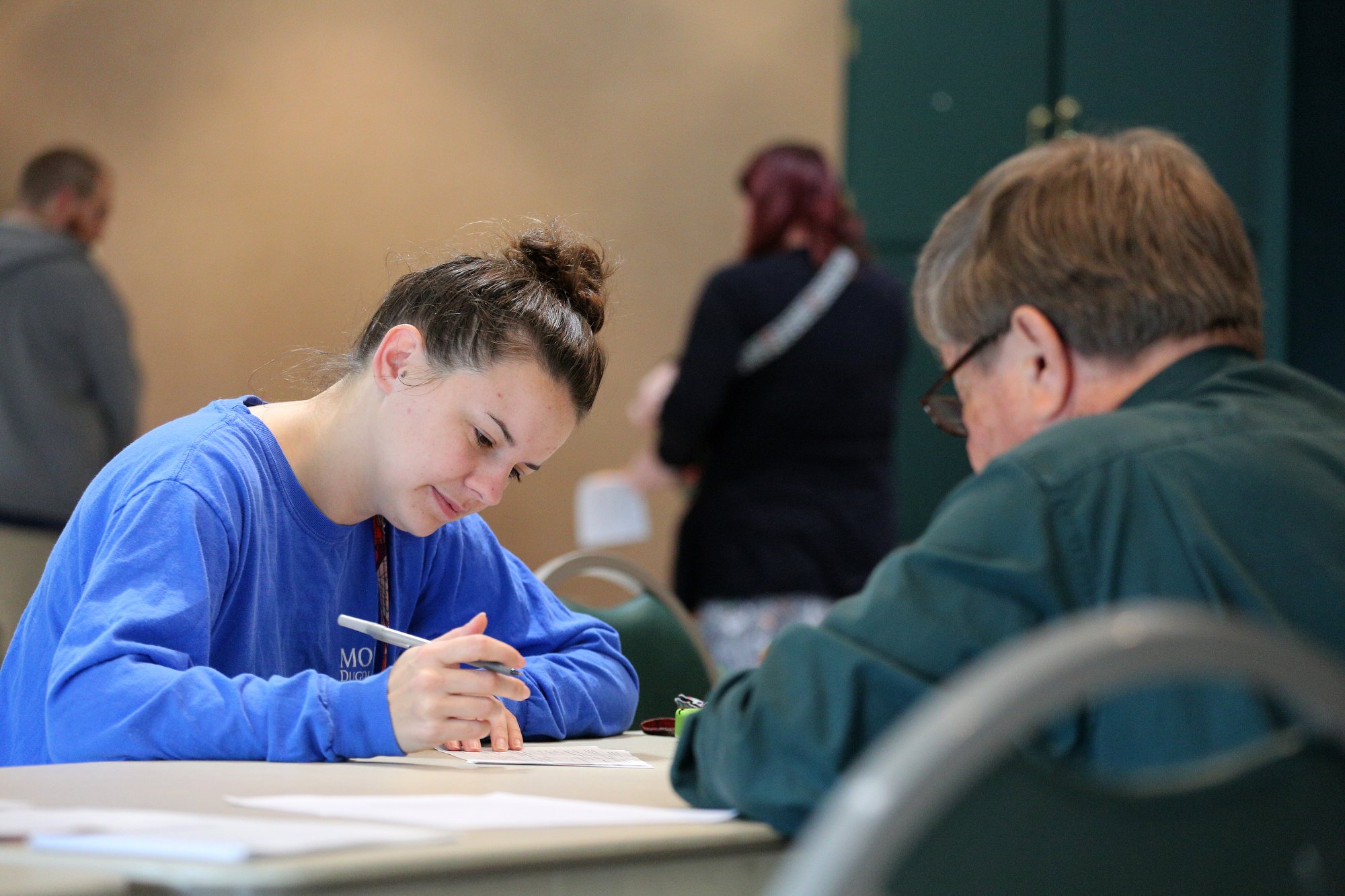 Lillie Lee fills out information before voting as Mike Hillis, an election official, looks on Tuesday, November 6, 2018 at Rossville City Hall in Rossville, Georgia. Tuesday was Lee's first time voting, and although she was running late for work due to stopping by the precinct, she wanted to make sure she voted.