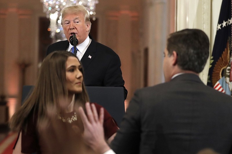 As President Donald Trump watches, a White House aide takes the microphone from CNN's Jim Acosta, during a news conference in the East Room of the White House, Wednesday, Nov. 7, 2018, in Washington. (AP Photo/Evan Vucci)

