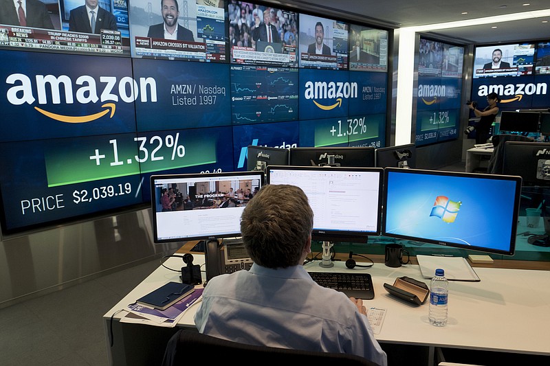 FILE- In this Sept. 4, 2018, file photo a Nasdaq employee monitors market activity in New York. Companies around the country and across industries are in the midst of reporting another quarter of gargantuan profit growth, driven by lower tax bills and a growing economy. Amazon said its net income surged more than tenfold during the summer from a year earlier, for example. (AP Photo/Mark Lennihan, File)