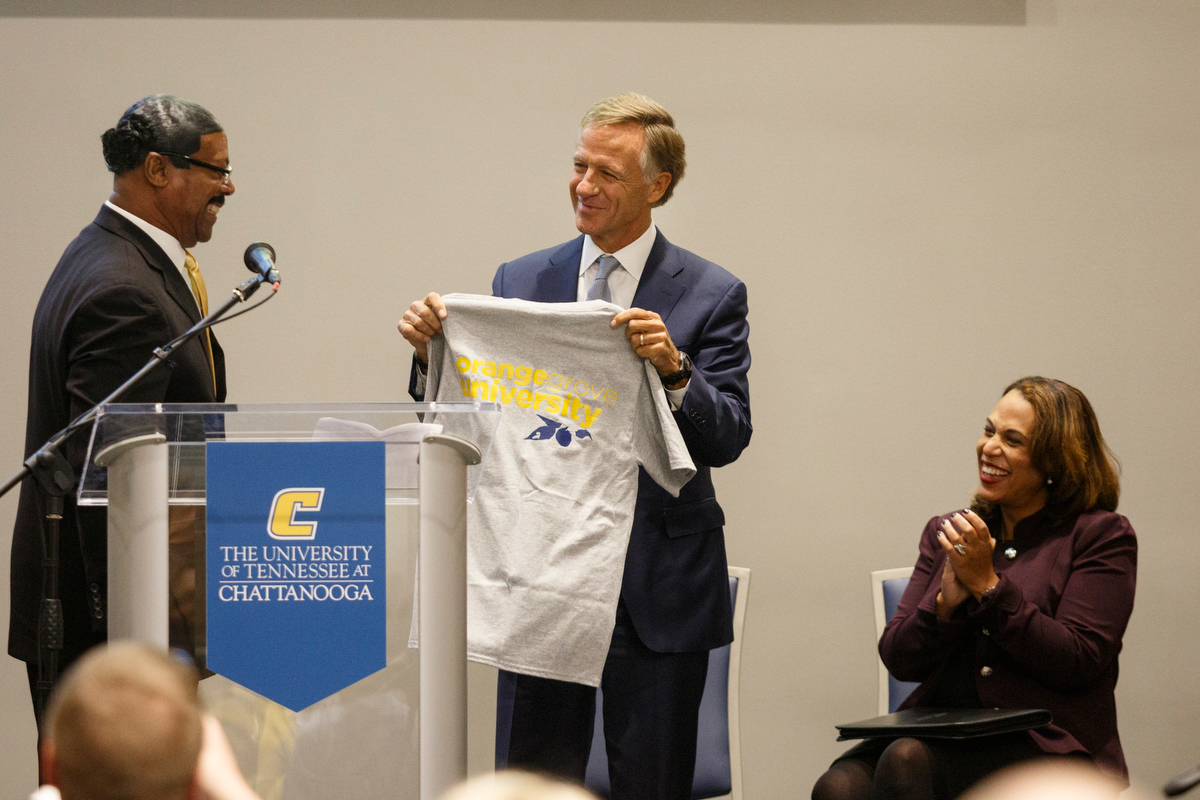 Executive Vice Chancellor Richard Brown, left, presents an Orange Grove University t-shirt to Gov. Bill Haslam during a visit to the campus of the University of Tennessee at Chattanooga on Thursday, Nov. 8, 2018, in Chattanooga, Tenn. Gov. Haslam released the fifth annual report by the Employment First Task Force during the visit, which shows the task force's efforts to increase employment for people with disabilities.