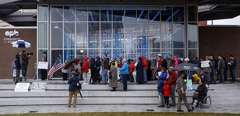 People listen as Camilo Payan, standing on a chair to the left, speaks during a MoveOn "No One is Above the Law" protest at Miller Park on Thursday, Nov. 8, 2018 in Chattanooga, Tenn. The protestors gathered to voice objections to President Trump's appointment of Matt Whitaker as acting attorney general. 