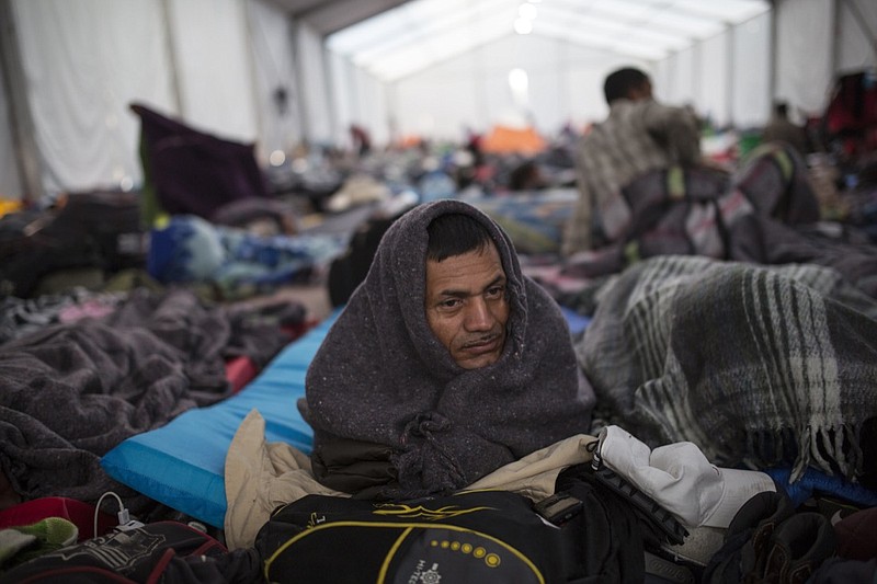 Alcides Padilla, from Honduras, wakes up at the Jesus Martinez stadium in Mexico City, Wednesday, Nov. 7, 2018. Central American migrants on Wednesday continued to straggle in for a rest stop at a Mexico City stadium, where about 4,500 continue to weigh offers to stay in Mexico against the desire of many to reach the U.S. border. (AP Photo/Rodrigo Abd)