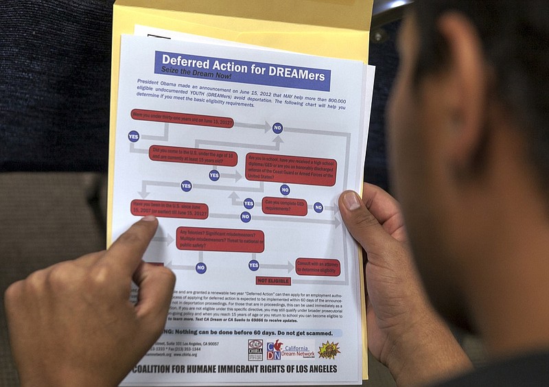 In this Aug. 15, 2012 file photo, a legal immigrant reads a guide of the conditions needed to apply for Obama-era Deferred Action for Childhood Arrivals (DACA) program at the Coalition for Humane Immigrant Rights, CHIRLA offices in Los Angeles. A U.S. appeals court ruled Thursday, Nov. 8, 2018, that President Donald Trump cannot immediately end the Obama-era program shielding young immigrants from deportation. A three-judge panel of the 9th U.S. Circuit Court of Appeals unanimously kept in place a preliminary injunction blocking Trump's decision to phase out the DACA program. (AP Photo/Damian Dovarganes, File)