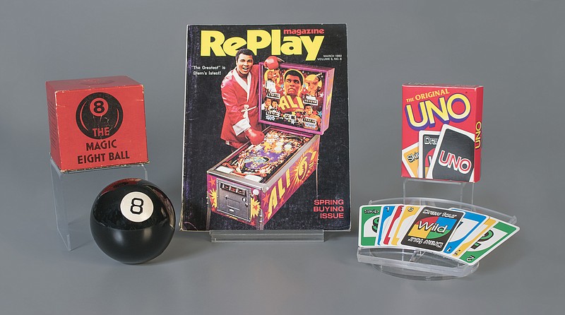 This October 2018 photo provided by The Strong museum shows the toys to be inducted into the National Toy Hall of Fame, inside the Rochester, N.Y., museum. The class of 2018 honored Thursday, Nov. 8, includes, from left, the Magic 8 Ball, pinball and the card game Uno. (Victoria Gray/The Strong via AP)