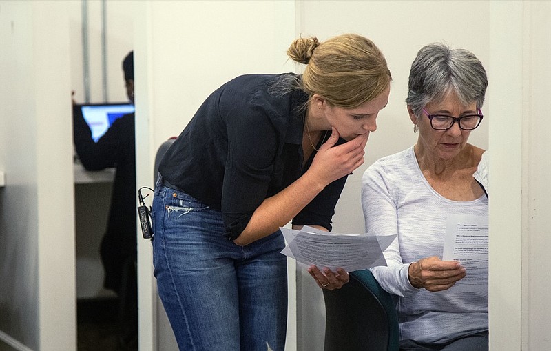 Helen Brosnan, left, an organizer with the National Domestic Workers Alliance, speaks with an unidentified volunteer in Atlanta, Ga., on Friday, Nov. 9, 2018. They are working to inform Georgia voters who used a provisional ballot to turn them into their election office. (AP Photo/ Ron Harris)